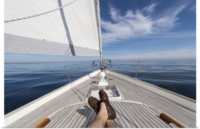 Man's feet crossed on sailboat