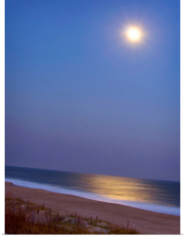 This large piece is a picture of the moon shining brightly over the beach and reflecting in the ocean.