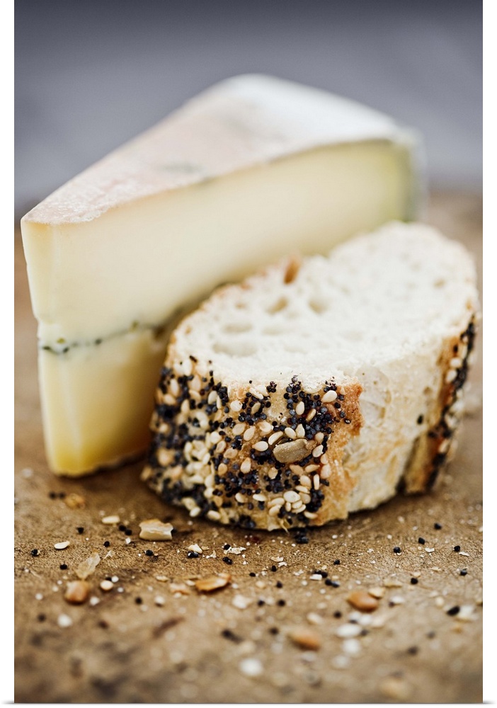 Morbier cheese on a board with seeded bread.