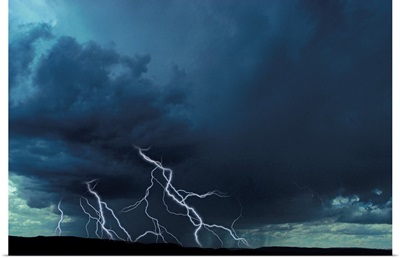 Multiple lightning bolts over rural landscape
