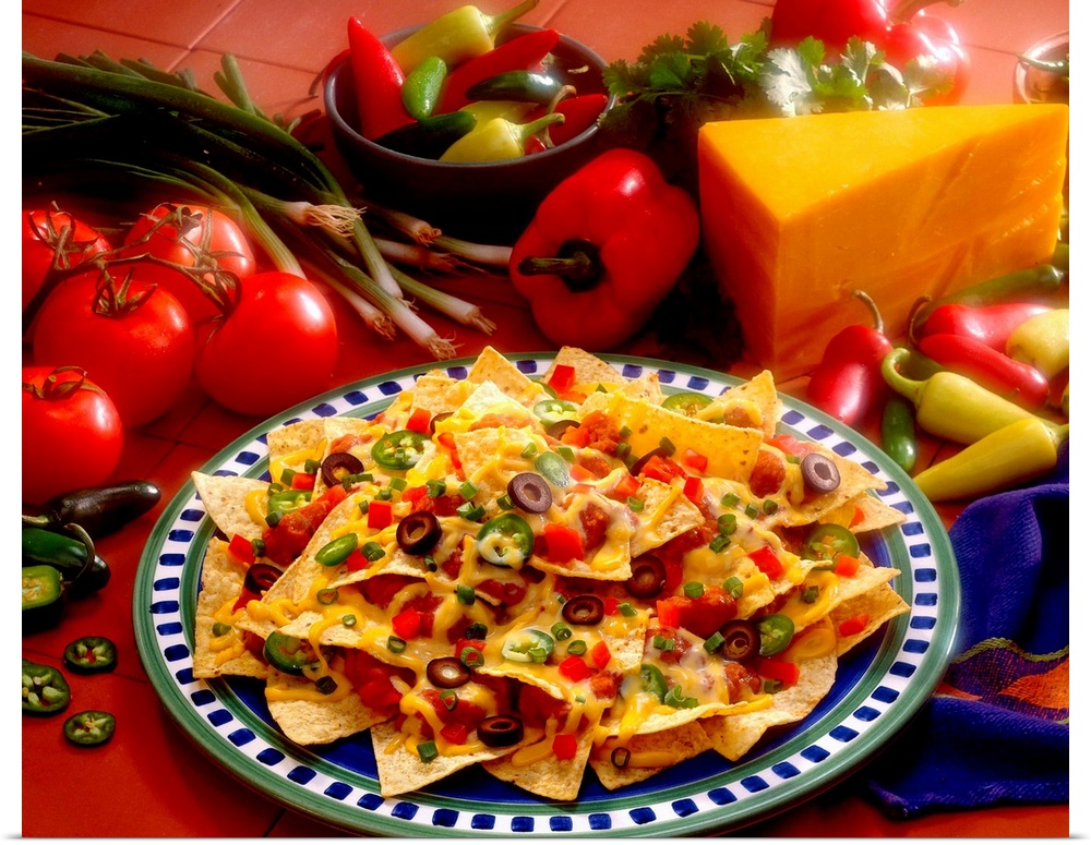 Horizontal photograph on a big canvas of a plate of loaded nachos, the fresh ingredients used on them are also surrounding...