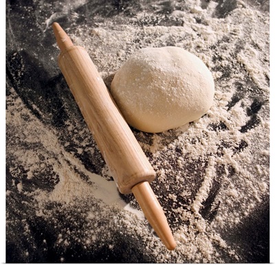 Overhead shot of a rolling pin, dough and flour on a counter