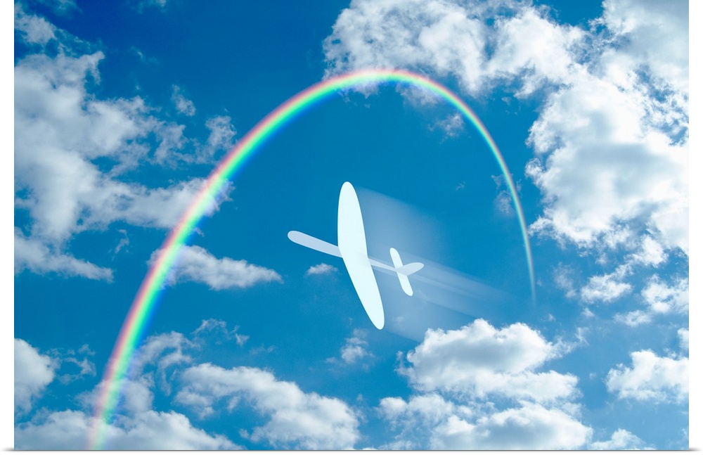 Paper airplane flying through a blue sky and clouds towards a rainbow