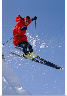 Person downhill skiing in mid air