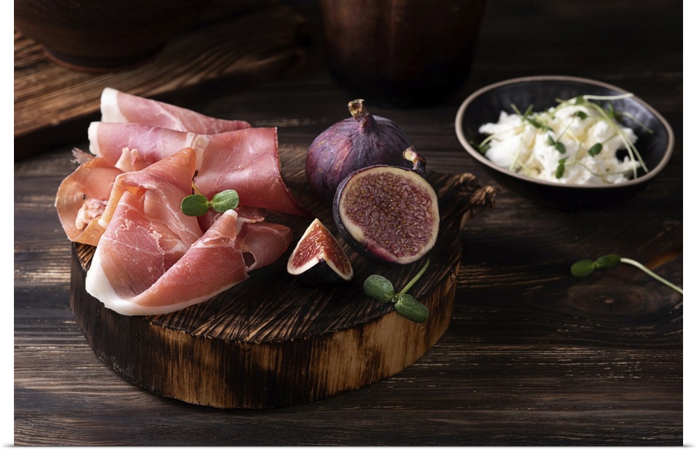 Prosciutto slices with figs on a dark wooden background, appetizer from dry cured ham. Rustic style. Ukraine.