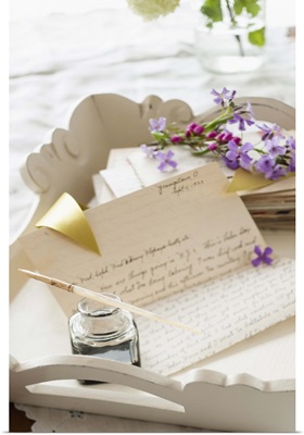 Quill pen with letters and flowers