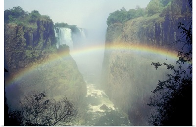 Rainbow over misty river canyon