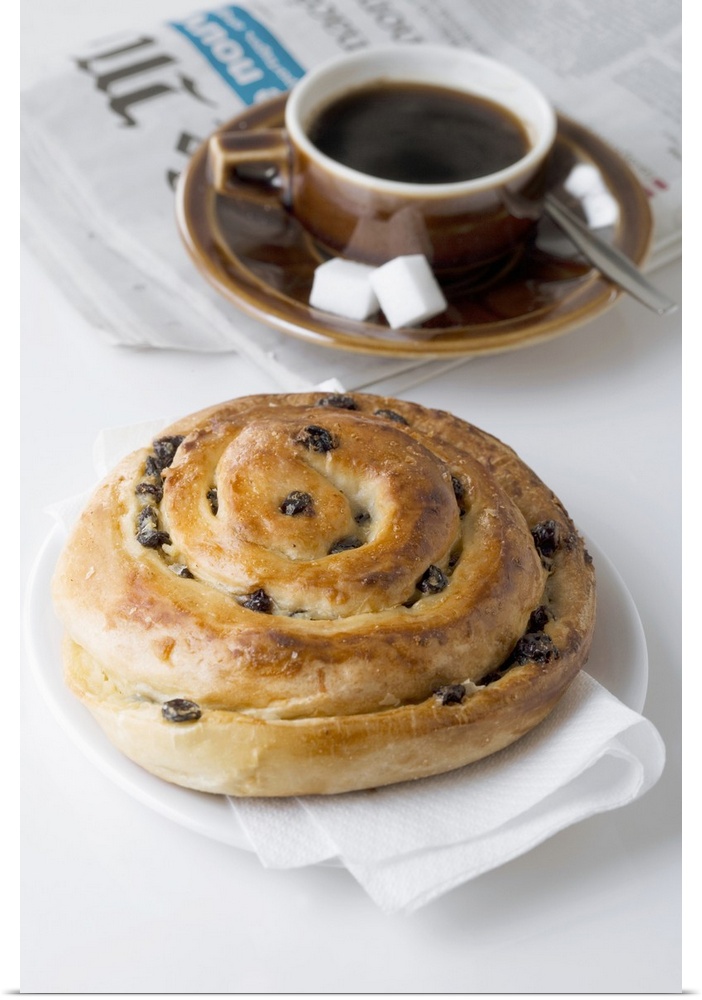 Raisin roll, coffee and newspaper on white background, close-up