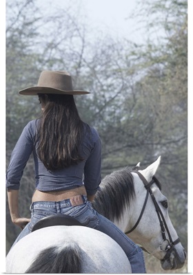 Rear View Of A Woman Riding A Horse