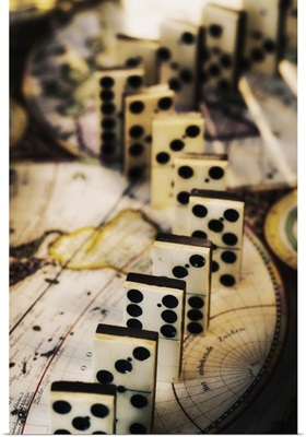 Row of dominoes on old world map