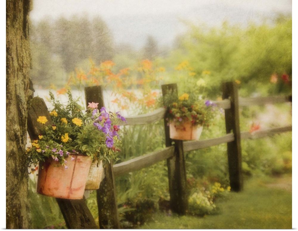 Rustic wooden fence with flowers in clay pots hanging on posts, with Mirror Lake and mountains of Lake Placid,NY in backgr...