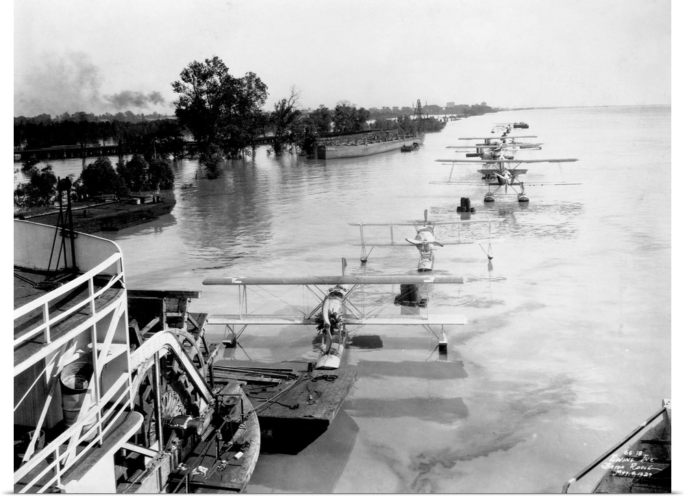 A sternwheeler tows a string of seaplanes down the Mississippi River during a flood. 1927.