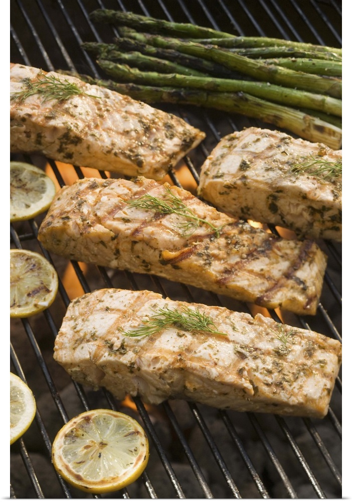 Fish and asparagus cooking on grill