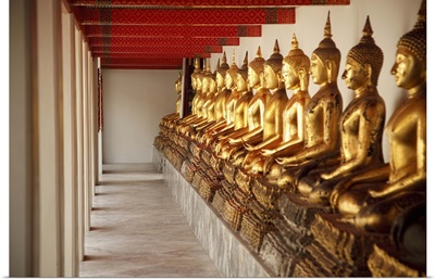 seated golden buddha statues in a row at wat pho, temple of the reclining buddha