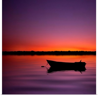 Silhouette boat in lake with sunset.
