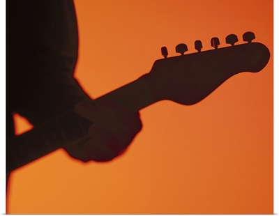 silhouette of a person playing a electric guitar