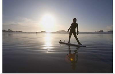 silhouette of female surfer doing yoga stretches