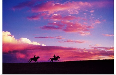Silhouette of horseback riders at sunset in Colorado