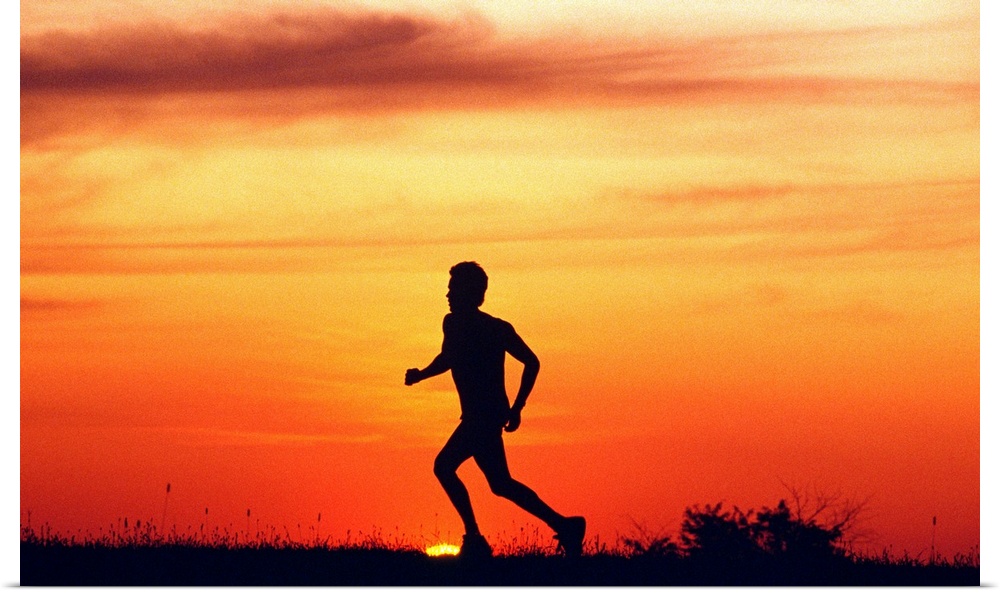 Silhouette of runner on ridge at sunset