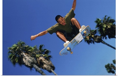 Skateboarder in mid-jump, low angle view