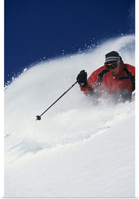 Skier riding down powdery mountains