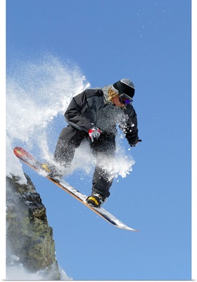Snowboarder jumping off ledge