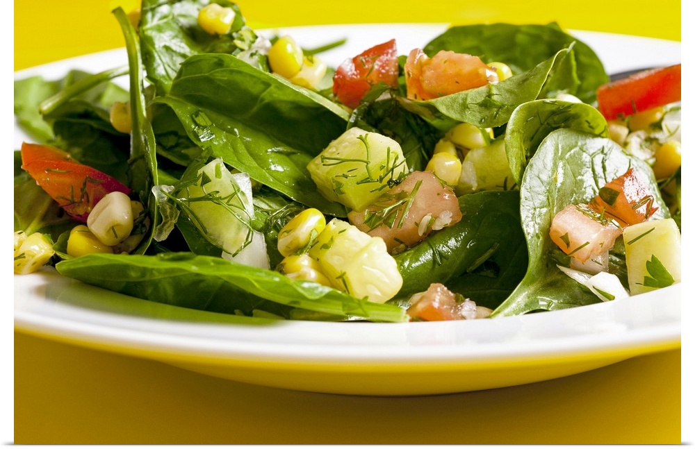 Spinach and sweet corn salad with tomatoes, cucumber and dill, close-up