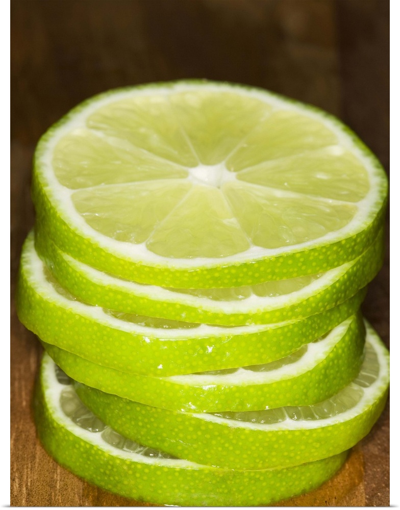 stacked sliced limes on wood cutting-board