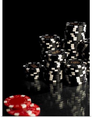 Stacks of black and white gambling chips, red chips in foreground