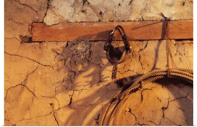 Still Life Of Spurs And Lasso Hanging On Adobe Wall