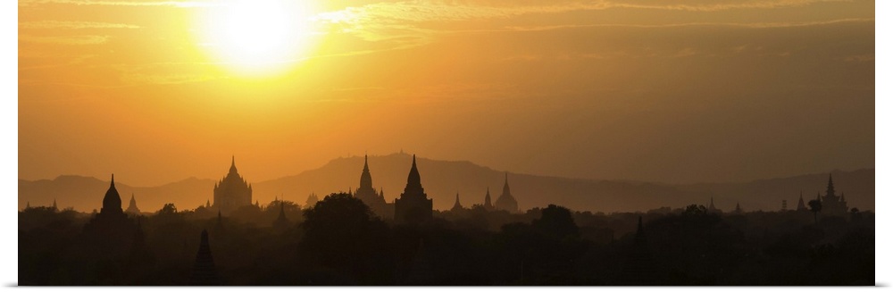 Panorama landscape showing silhouettes of pagodas, temples and trees in Bagan, Myanmar (Burma) during sunset. Bagan is a s...