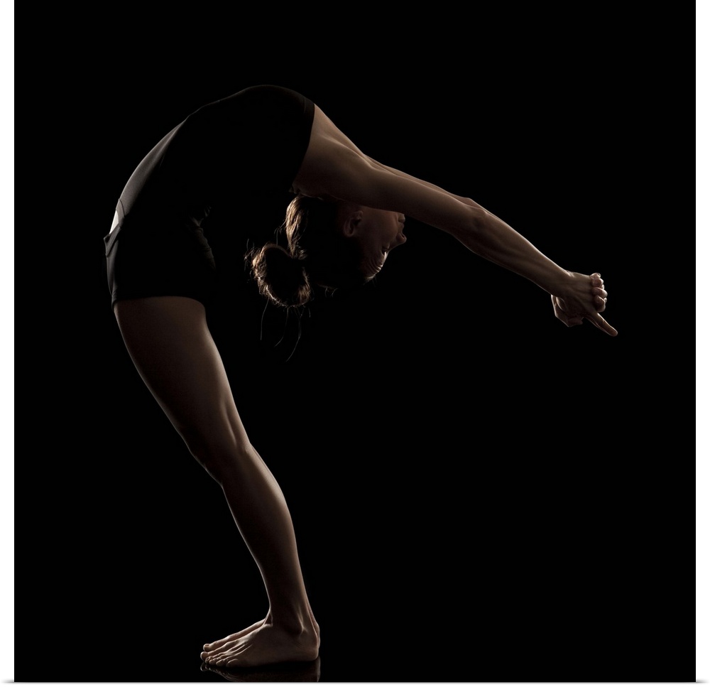 Studio shot of young woman practicing yoga.  The half moon pose, ardha chandrasana.