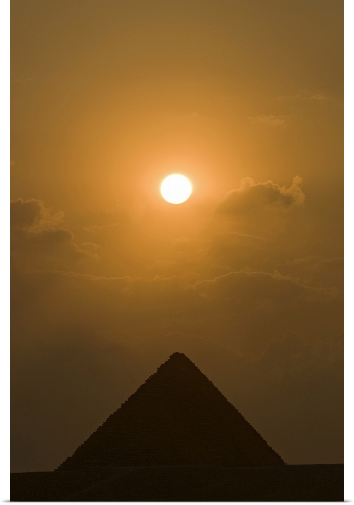 The sun begins to set above The Great Pyramid of Giza, in Cairo, Egypt.
