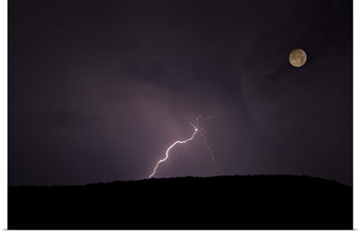 Thunderstorm, thunderbolt lightning, flash over mountain and moon at night.