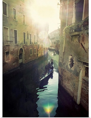 Two gondolas floating in water surrounded by old buildings.