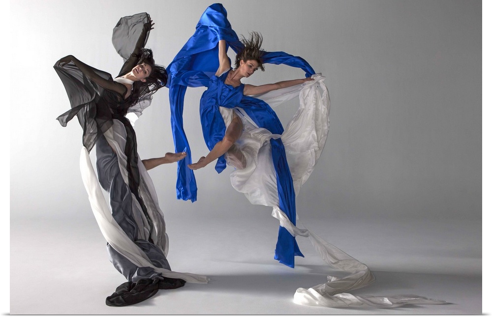 Two ballet dancers jumping together, draped in silk, fabric flows beautifully with there movement