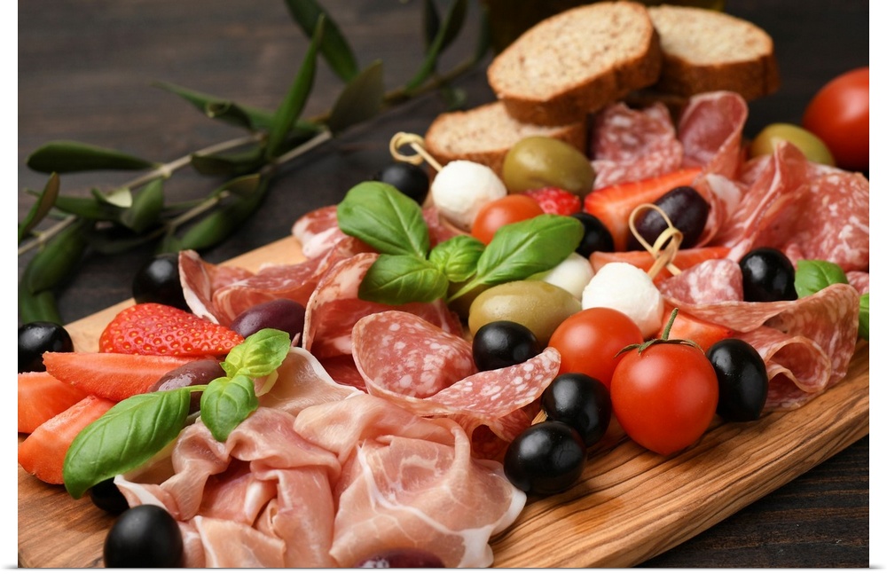 Typical antipasto in an Italian restaurant salami, ham prosciutto, with green and black olives, appetizers with mozzarella...