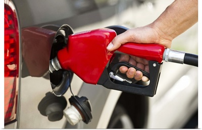 USA, New Jersey, Jersey City, Hand holding fuel pump refueling car