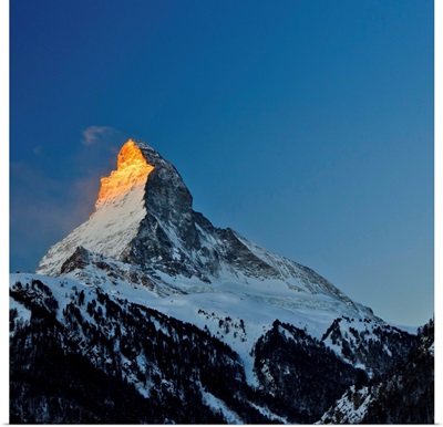 View of Matterhorn, Alps, in sunrise, blue sky in background.