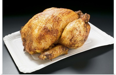Whole roast chicken on paper plate