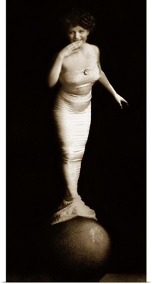 Woman in mermaid costume balancing on ball