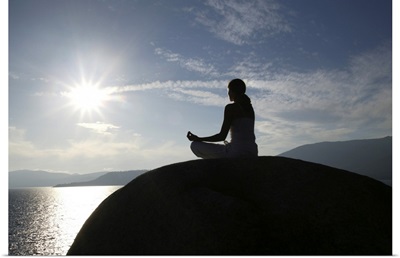 Woman meditating on rock