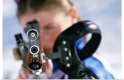 Woman shooting rifle in biathlon (focus on nozzle)