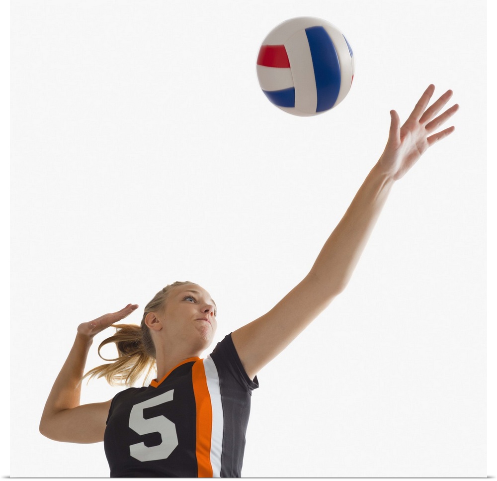 Young girl (16-17) playing volleyball