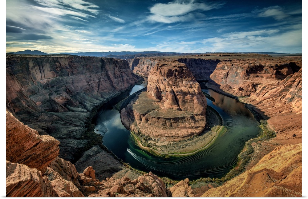 A boat rounds the tip of the iconic Horseshoe Bend near Page, Arizona.