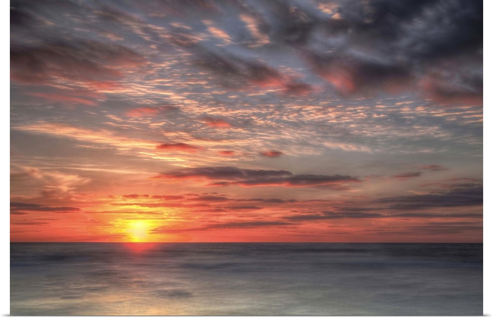 A coastal photograph of a seascape at sunrise.