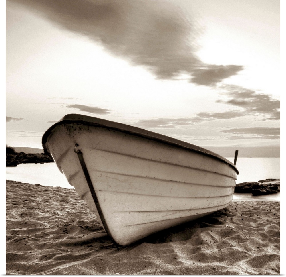 A square image of a small white boat pulled up onto a sandy beach with a dramatic line of clouds above.