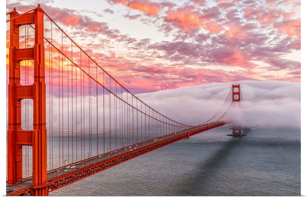 A dynamic photograph of the golden gate bridge disappearing in a thick blanket of clouds.