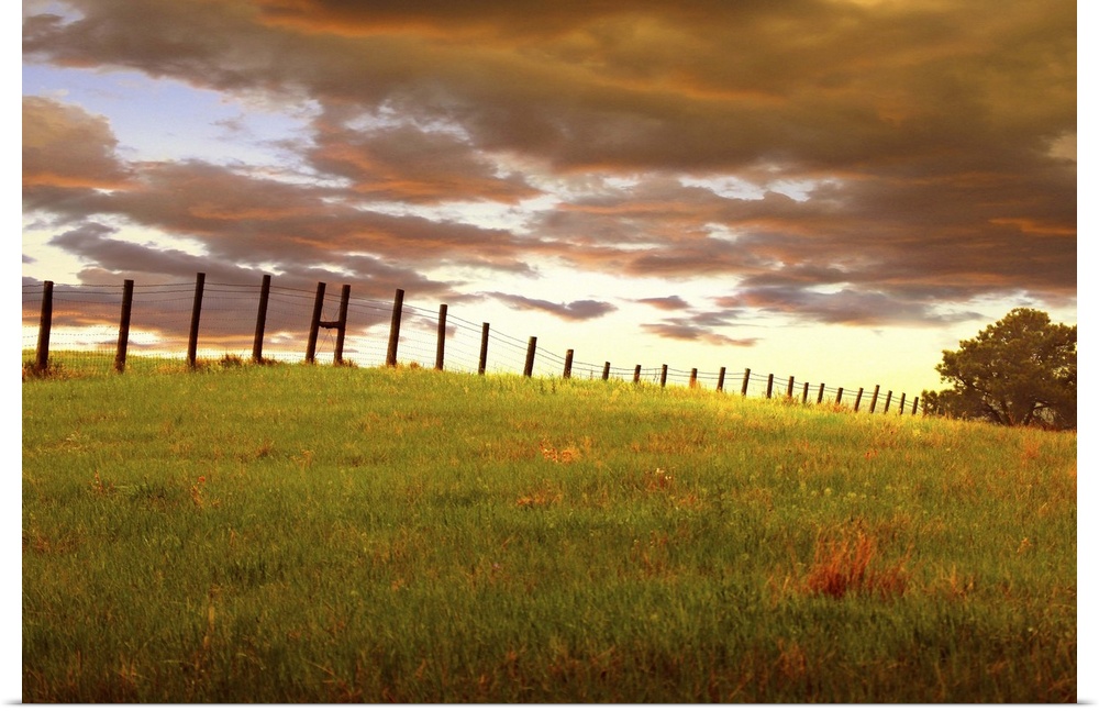 Sunset with dramatic clouds over a fenced field, near Custer State Park, South Dakota.