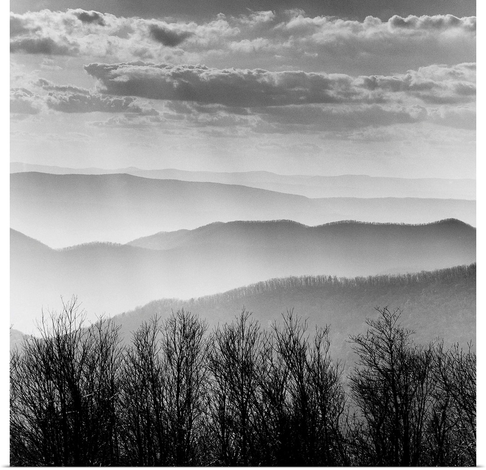 Square black and white image of the rolling mountains of the Blue Ridge with mist and layers of clouds.